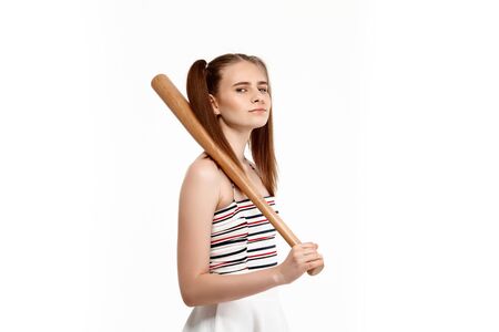 Young brutal pretty girl posing with bat, isolated on white background. Copy space.の写真素材
