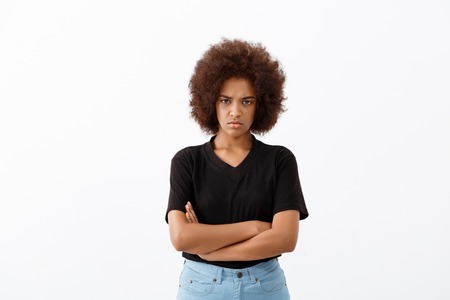 Upset young beautiful african girl looking at camera over light background. Copy space.の写真素材