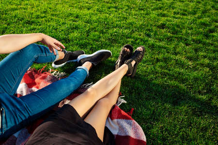 Couple lying and relaxing on grass. Close up of legs.の写真素材