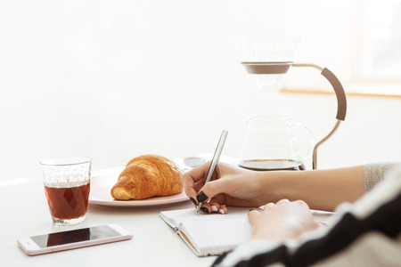 Woman sitting in big illuminated room with pleasant natural lighting.の写真素材