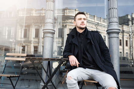 Young man enjoying wonderful day, smiling cheerfully, looking away thougtfully.の写真素材