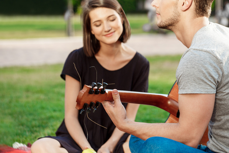 Young beautiful couple smiling, resting on picnic in park.の写真素材