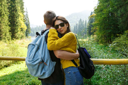 Young beautiful couple smiling, embracing, enjoying mountains lanscape.の写真素材