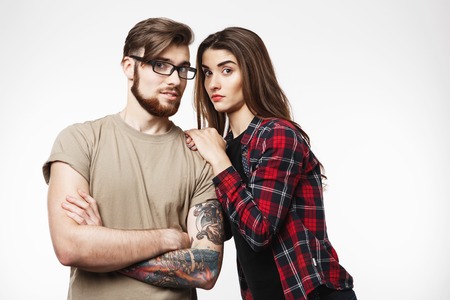 Young couple in cool trendy look frowning at camera, looking shocked. Isolated on white background.の写真素材