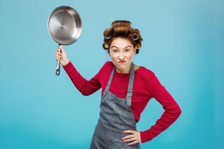 Nice girl tries to scare you holding frying panの写真素材