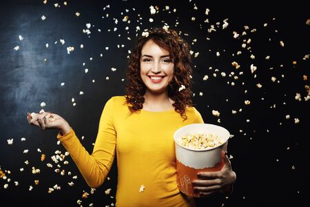 Popcorn battle. Frineds having fun at home party throwing popcornの写真素材