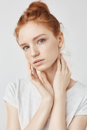 Portrait of beautiful natural redhead girl over white background looking staright at cameraの写真素材