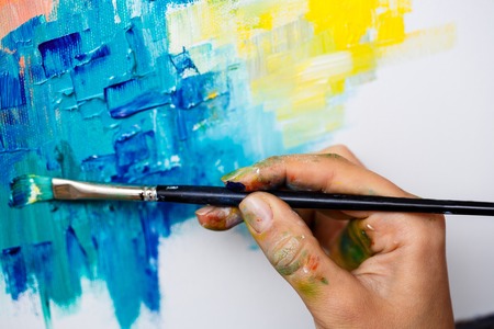 Close up of girl drawing with oil paints on canvas.の写真素材