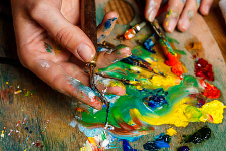 Close up photo of girl mixing oil paints on palette.の写真素材