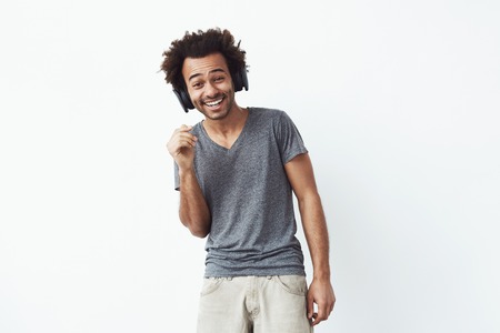 Handsome cheerful african man in headphones  laughing. Isolated on white background.
