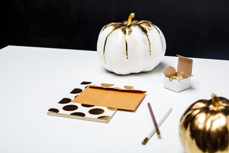 Halloween decor on white table over black background.の写真素材