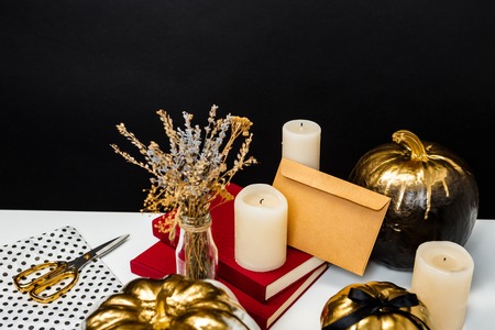 Halloween decor on white table over black background.