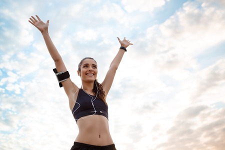 Young beautiful sportive girl training at sunrise over seaside.の写真素材