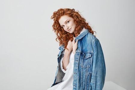 Beautiful foxy girl smiling looking at camera posing over white background.の写真素材