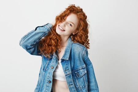 Cheerful redhead girl smiling laughing looking at camera over white background. Copy space.の写真素材