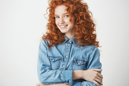 Playful beautiful redhead girl smiling looking at camera. White background. Copy space.の写真素材