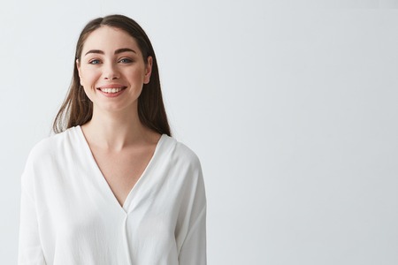 Portrait of happy beautiful young businesswoman smiling looking at camera over white background.の写真素材