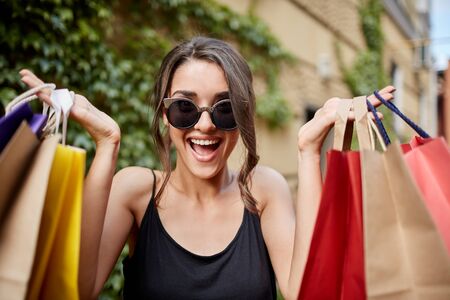 Close up portrait of happy joyful young dark-haired caucasian woman in tab glasses and black shirt...