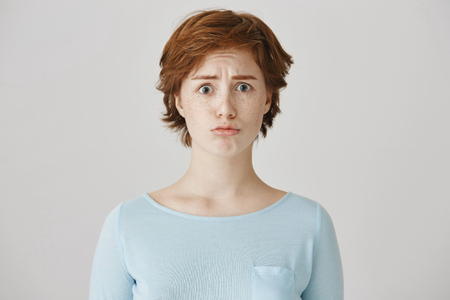 But you promised to come with me. upset adorable redhead female student, frowning and sulking, wanting to cry over gray background. Girlfriend was offended and now do not speak with anyoneの写真素材