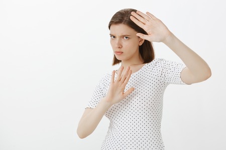 Girl gonna protect herself from paparazzi. Portrait of intense angry and annoyed woman, covering...