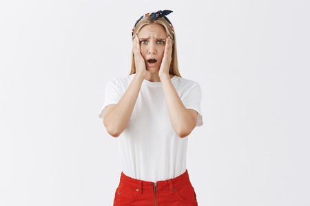 Good-looking young blonde female tried make cake feeling sad and gloomy it ruined, frowning holding...