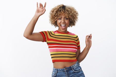 Excited and happy girl having fun at party yelling from joy and thrill as dancing, enjoying cool...