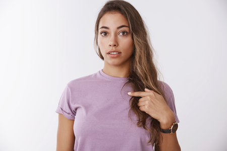 Surprised girl did not expect picked, pointing shocked herself questioned indicating chest amazed winning unexpected gift, standing stunned cant believe lucky day, standing white backgroundの写真素材