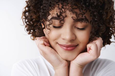 Headshot tender feminine dreamy young romantic curly-haired attractive girl close eyes smiling...