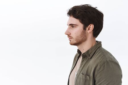 Profile portrait of ordinary caucasian guy with bristle, looking left at blank white cope space, no...