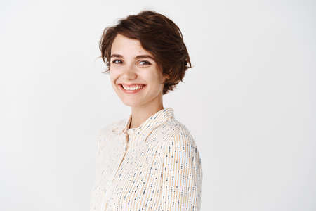 Young female entrepreneur smiling at camera and looking confident, standing over white backgroundの写真素材