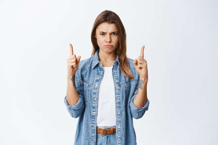 Thats bad. Upset young woman complain on unfair situation, frowning and sulking angry, pointing...