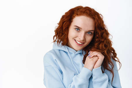 Close up portrait of flirty and lovely redhead girl making coquettish face to seduce you, smiling...