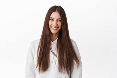 Beautiful brunette woman with long healthy shiny hair, smiling and looking happy, advertising of...