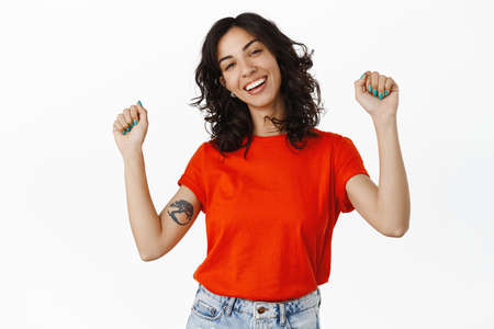 Dancing queer girl laughing, raising hands up and celebrating pride month lgbtq concept, having fun,...