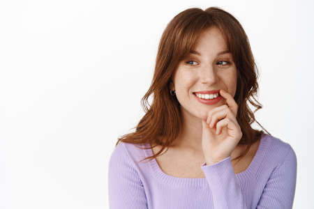 Close up portrait of smiling thoughtful girl, fashionable clothes and makeup, looking happy aside,...