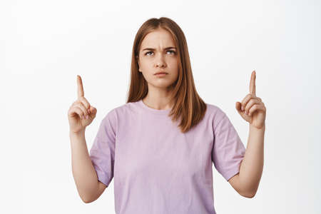 I disagree. Frowning girl looks upset, pointing and looking up with furrow eyebrows, judging smth...