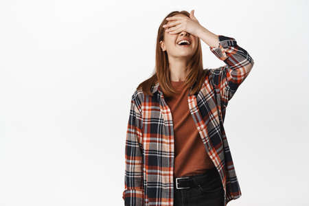 Image of happy blond girl waiting for surprise, close eyes, cover with hand and smiling excited,...