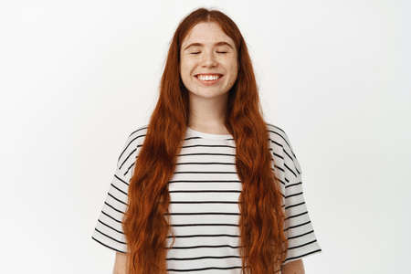 Image of beautiful redhead curvy woman with eyes closed, dream of something with happy face, smiling...