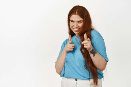You got this, well done. Smiling redhead girl encourage you, boosting confidence, pointing fingers...