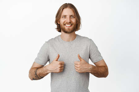 Nice job man, like it. Pleased good-looking happy male friend with blond hair and brislte, showing...