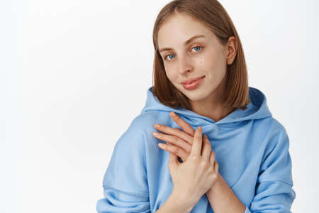 Close up portrait of tender and feminine cute girl, holding hands near chest.の写真素材