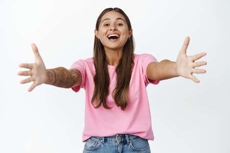 Happy girl stretch out hands towards you. Woman shows friendly welcome, approaching to camera for...