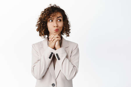 Thoughtful businesswoman looking right with yearning, wants to try smth, thinking, standing in beige...