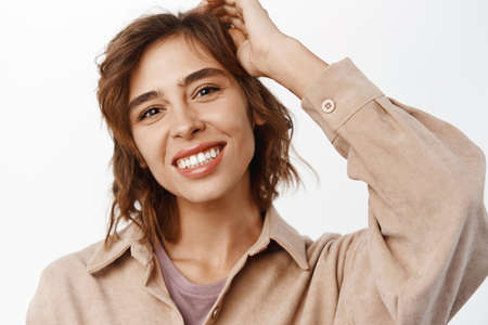 Beauty. Feminine young woman with curly short hairstyle, white smile, natural clear skin without...