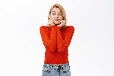 Excited young woman anticipating, looking at something with fascinated, admiring face expression,...