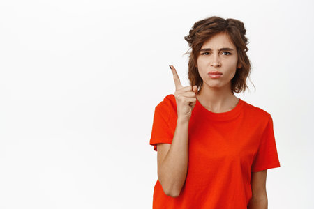 Angry disappointed woman shaking finger, scolding, frowning displeased, standing upset by someone against white backgroundの写真素材