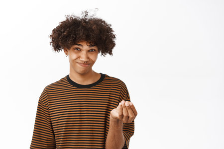 Give me money. Broke young hispanic guy showing cash gesture, standing over white studio backgroundの写真素材