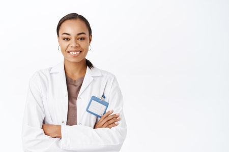 Portrait of smiling female doctor, therapist in white coat, looking confident with arms crossed. Medical healthcare conceptの写真素材