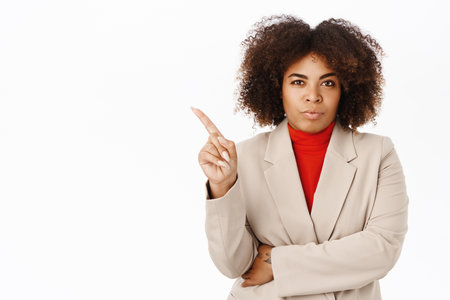 Corporate people. Serious african businesswoman, lady boss shakes finger in disapproval, prohibit or reject smth, stands over white backgroundの写真素材