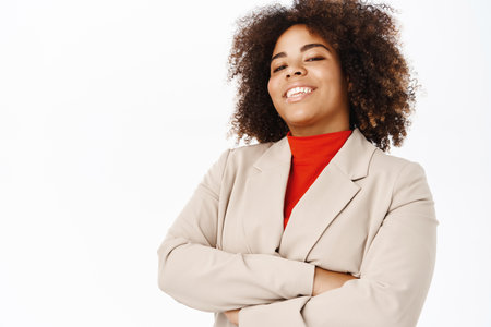 Portrait of smiling african american businesswoman, corporate worker cross arms on chest, professional power pose, standing over white backgroundの写真素材
